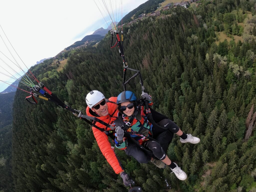 Parapente biplace en vol au-dessus de la vallée de Bozel