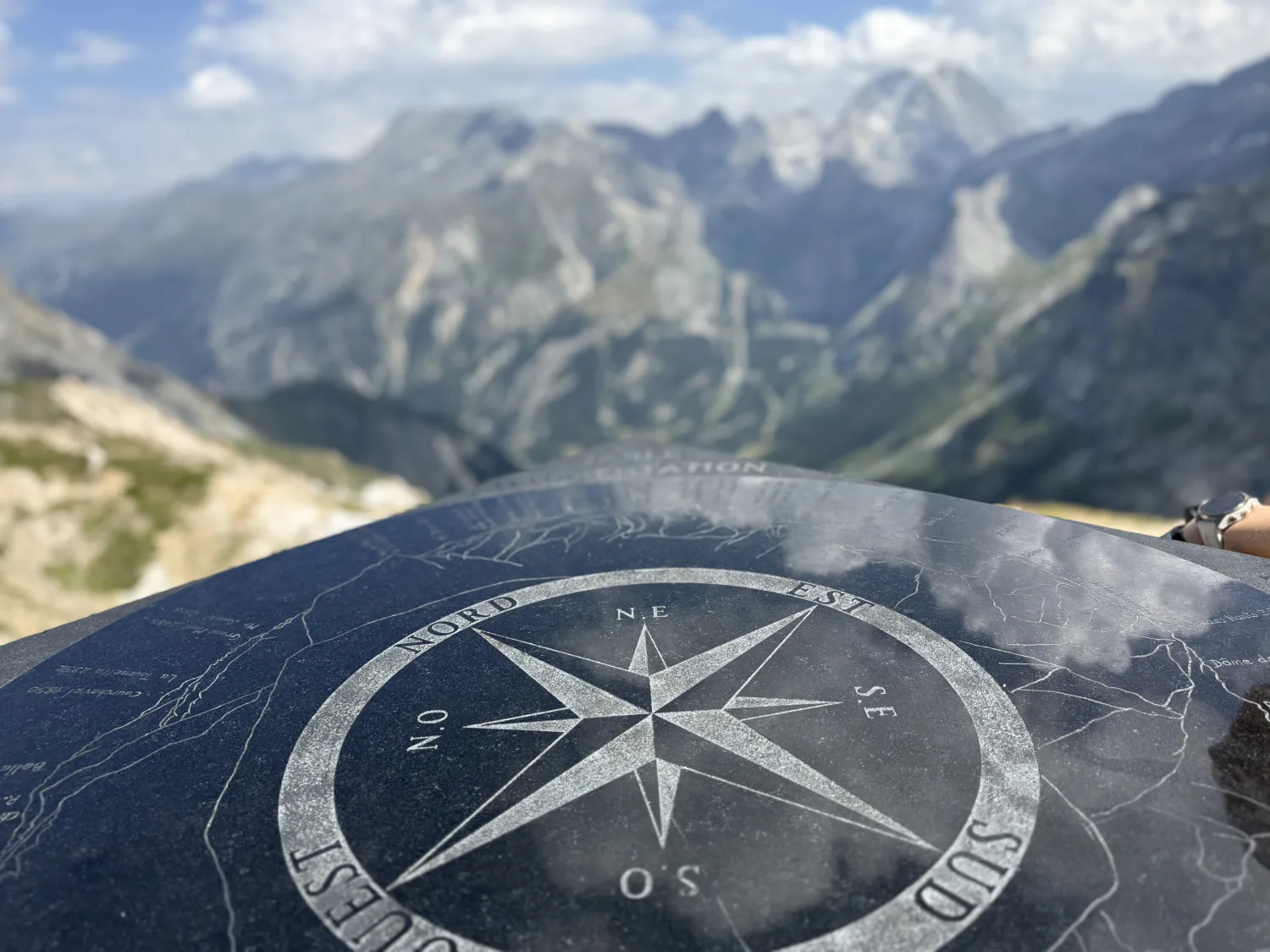 Table d'orientation en pierre gravée au sommet du Petit Mont Blanc avec rose des vents et vue plongeante sur la vallée